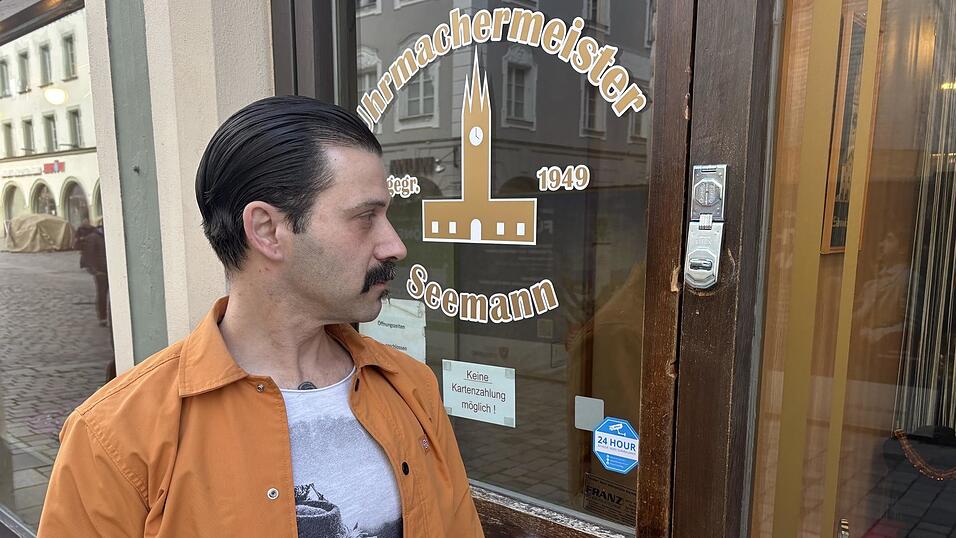 Andreas Seemann schaut auf die Hebelspuren an der Holzt&uuml;r zu seinem Laden im Stadtturm.