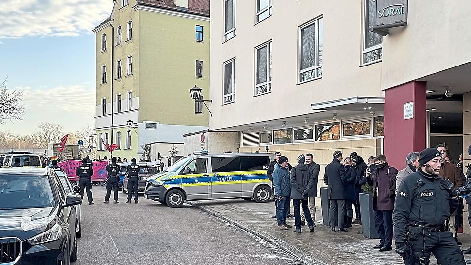 Die AfD-Abgeordneten vor dem Hotel, im Hintergrund ein Teil des Gegenprotests.