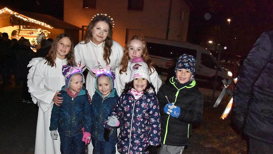 Gruppenbild mit Christkind: Kleine Besucher scharten sich um Lisa Roman (hintere Reihe, 2.v.l.) und ihre 'Engel', die bei der Er&ouml;ffnung des Weihnachtsmarkts der Altstadtfreunde den Prolog sprach.