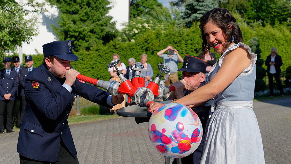Festleiter Johannes Huber (links) und Vorstand Stephan Hanusch beim Aufpusten des Luftballons, der von Festmutter Heidi Wieland gehalten wird
