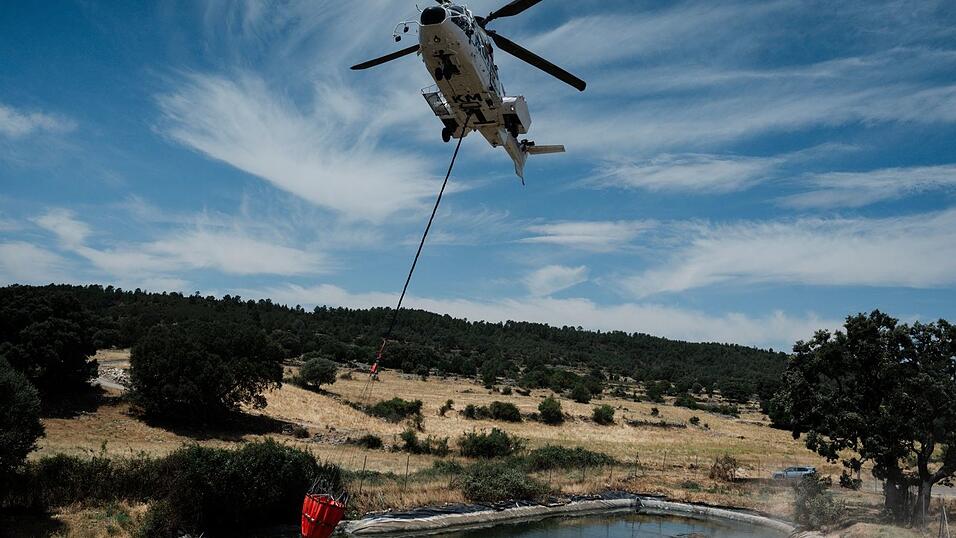 Ein Hubschrauber unterstützt die Löscharbeiten in dem Gebiet von Guadalajara bei Madrid. Ein Hubschrauber unterstützt die Löscharbeiten in dem Gebiet von Guadalajara bei Madrid.