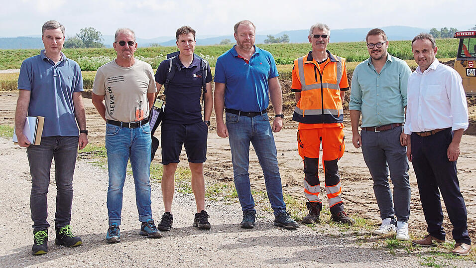 Trafen sich beim Baustart am Montag zu einer Besprechung vor Ort: Matthias Kufner und Roland Riedl von der Firma Streicher, Thomas Poxleitner und Andreas Schmid vom B&uuml;ro S&sup2;, der W&ouml;rther Wasserwart Alfons Ebner, Bauamtsleiter Daniel Reichl und B&uuml;rgermeister Josef Sch&uuml;tz (von links). Im Hintergrund sind die Baustelle und der Donaudamm zu sehen.