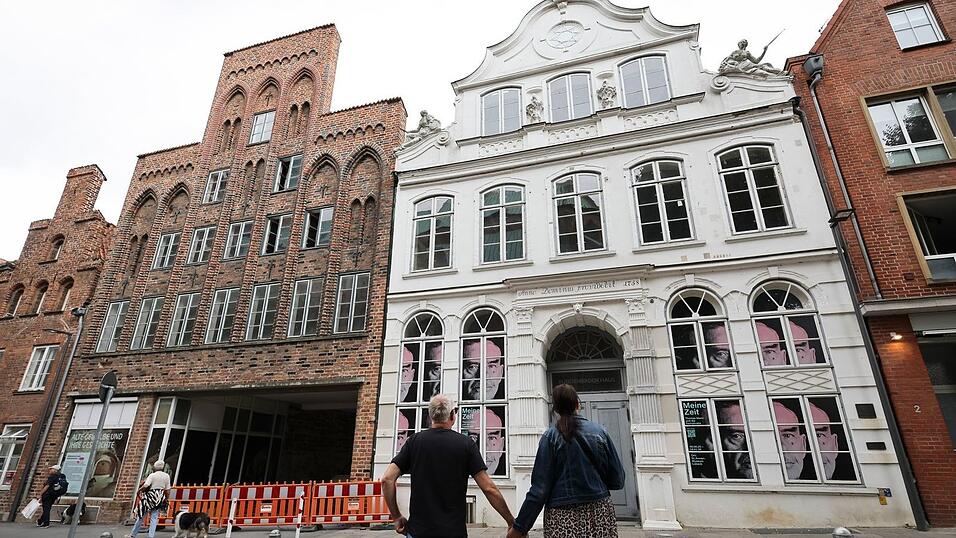 Passanten betrachten das geschlossene Buddenbrookhaus in der L&uuml;becker Altstadt.
