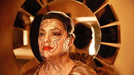 Anna Netrebko hat gerade eine Art Biografie in Form eines Kochbuchs herausgebracht - da könnte man den Gesichtsschmuck des Fotos für ihr Album glatt für vergoldete Nudeln halten.