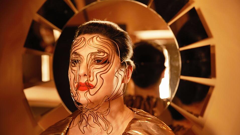 Anna Netrebko hat gerade eine Art Biografie in Form eines Kochbuchs herausgebracht - da könnte man den Gesichtsschmuck des Fotos für ihr Album glatt für vergoldete Nudeln halten.
