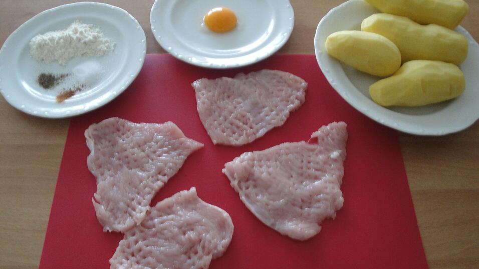 Die Zutaten für die Schnitzel in Kartoffelkruste: Zwei Putenschnitzel, Kartoffeln, ein Eigelb, Mehl und Gewürze.
