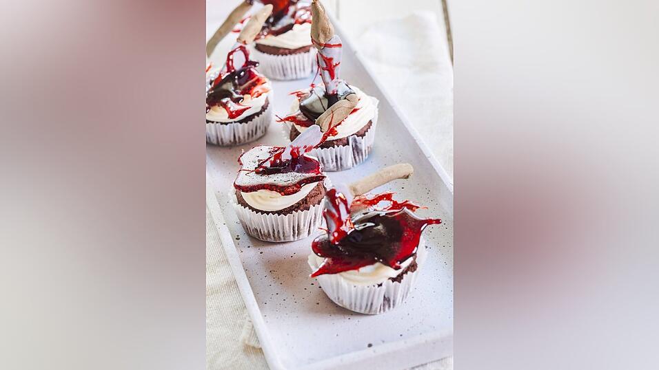Das sind Halloween-Cupcakes mit einer Axt in Zuckerblut.