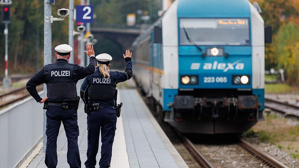 Bundespolizisten weisen per Handzeichen den Lokf&uuml;hrer eines Zuges aus Prag in Richtung M&uuml;nchen darauf hin, dass sie zur Kontrolle des Einreiseverkehrs zusteigen werden. (Archivbild)