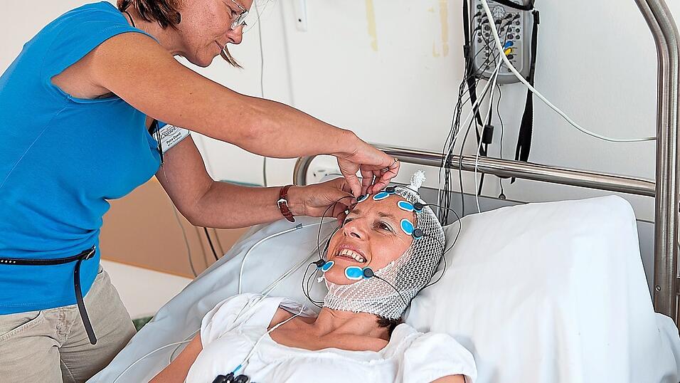 Eine Patientin wird im Klinikum für ihre Nacht im Schlaflabor verkabelt.