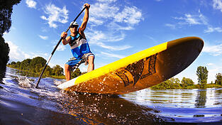 Beim Stand-Up-Paddeln steht der Sportler aufrecht auf einer Art Surfbrett, das in der Regel wesentlich breiter ist, und mit einem Stechpaddel Vortrieb zur Fortbewegung erzeugt. (Foto: Andreas Arnold, dpa) Beim Stand-Up-Paddeln steht der Sportler aufrecht auf einer Art Surfbrett, das in der Regel wesentlich breiter ist, und mit einem Stechpaddel Vortrieb zur Fortbewegung erzeugt. (Foto: Andreas Arnold, dpa)