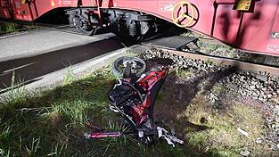 Das Motorrad des 17-J&auml;hrigen liegt neben dem Bahn&uuml;bergang, an dem der Zug zu stehen gekommen ist. Der Vorderreifen wurde beim Aufprall weggeschleudert.&nbsp;