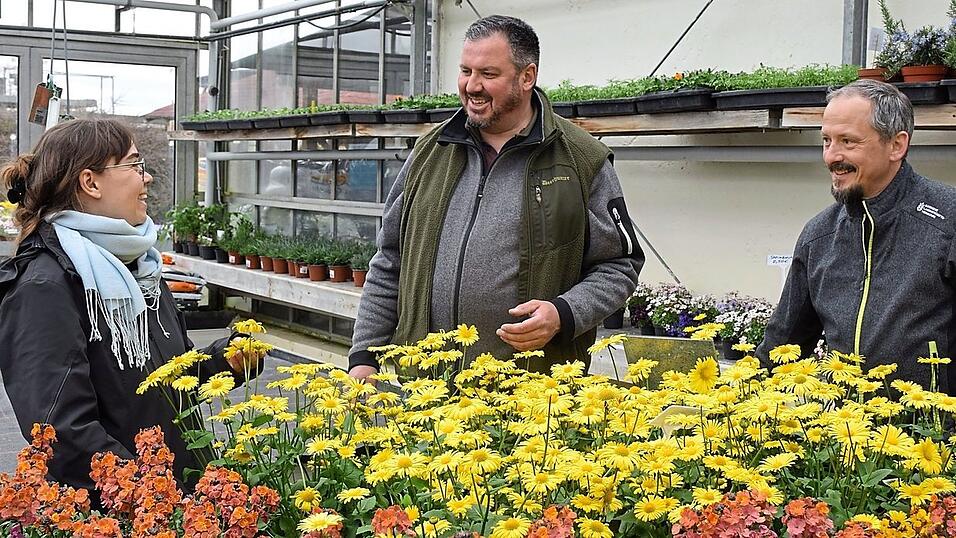 Werkstudentin Janina Sendlinger, Betriebsleiter Stefan Pahnke und Florian Hageneder vom AELF Abensberg-Landshut (v.l.n.r.) begutachten die Zierpflanzen-Auswahl im Verkaufsraum der G&auml;rtnerei der Isar-Sempt-Werkst&auml;tten.