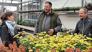 Werkstudentin Janina Sendlinger, Betriebsleiter Stefan Pahnke und Florian Hageneder vom AELF Abensberg-Landshut (v.l.n.r.) begutachten die Zierpflanzen-Auswahl im Verkaufsraum der G&auml;rtnerei der Isar-Sempt-Werkst&auml;tten.
