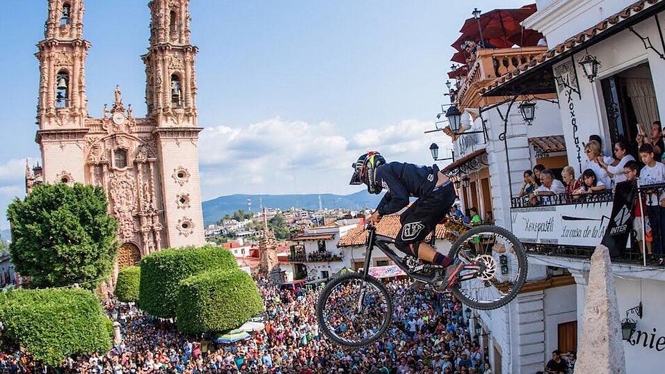 Ein Teilnehmer des Downhill Taxco, im Hintergrund die Kathedrale Santa Prisca im mexikanischen Taxco.