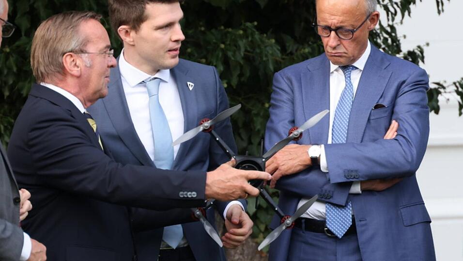 Verteidigungsminister Boris Pistorius (l.) reicht Bundeskanzler Friedrich Merz (r.) eine Drohne: Was in der Autoindustrie an B&ouml;rsenwert und Arbeitspl&auml;tzen verloren geht, soll in der deutschen R&uuml;stungsindustrie wenigstens zum Teil ausgeglichen werden, das ist das Signal, das von der Regierung Merz ausgeht.