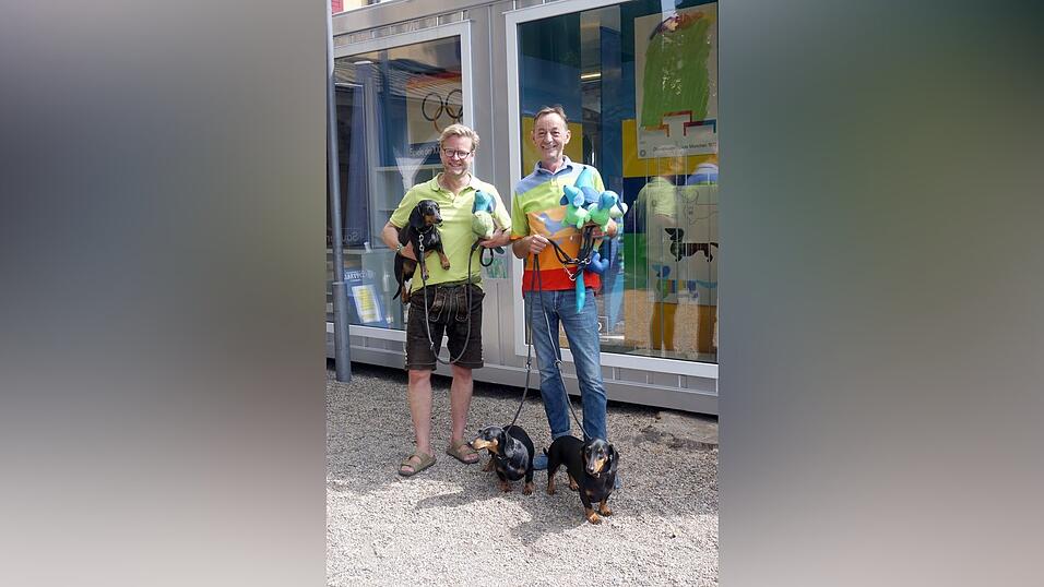 Oliver Storz und Seppi K&uuml;blbeck mit ihren drei Dackeln Moni, Seppi und Bl&uuml;mchen vor dem Kunstcontainer im Spitalgarten.