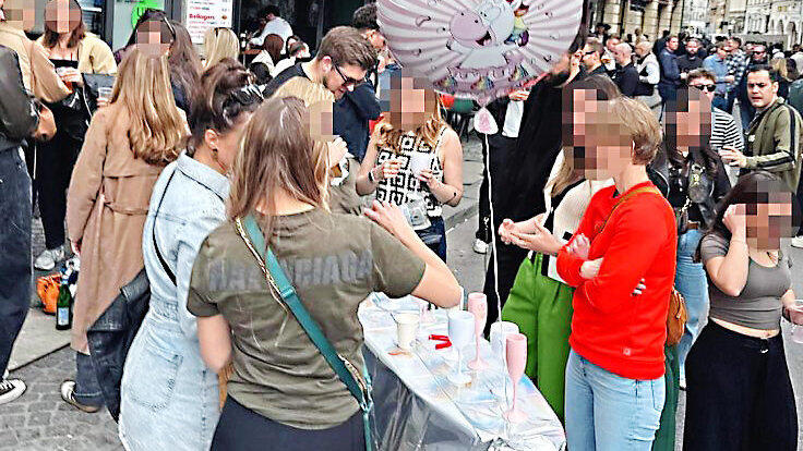 Trinklust macht kreativ: Feierfreudige auf dem Viktualienmarkt verwandeln ein B&uuml;gelbrett in einen Tresen.