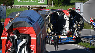 Zwei auseinandergeschnittene Waggonteile sind auf der Bundesstraße abgestellt und werden für den Weitertransport vorbereitet. Drei Tage nach dem Zugunglück von Garmisch-Partenkirchen gehen die Aufräumarbeiten voran.