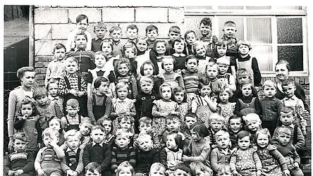 Das alte Foto zeigt Martha Schilling als Leiterin eines Kindergartens mit 72 Buben und M&auml;dchen und einer Helferin.