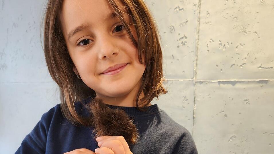 Lena Aigner zeigt stolz ihren abgeschnittenen Zopf.