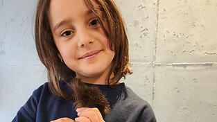 Lena Aigner zeigt stolz ihren abgeschnittenen Zopf.