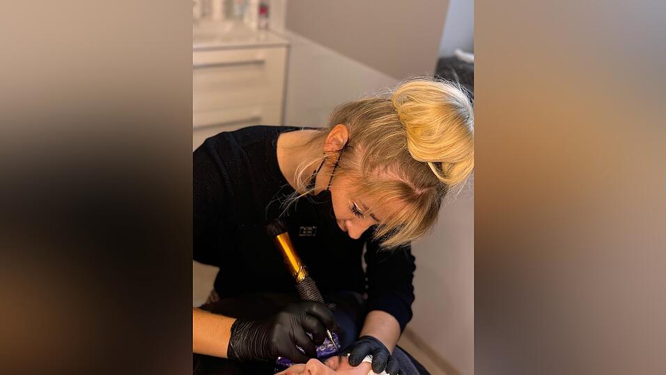 Hochkonzentriert tätowiert Berger feinste Augenbrauenhärchen.