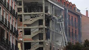 Feuerwehrleute arbeiten nach der schweren Explosion an dem beschädigten Gebäude in Madrids Toledo Straße. Feuerwehrleute arbeiten nach der schweren Explosion an dem beschädigten Gebäude in Madrids Toledo Straße.