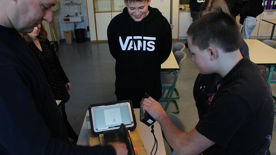 Christian Geiger (l.) zeigt den Schülern der 8. und 9. Klasse, wie sie ein Lasermessgerät an einem Radreifen aus Stahl verwenden. Christian Geiger (l.) zeigt den Schülern der 8. und 9. Klasse, wie sie ein Lasermessgerät an einem Radreifen aus Stahl verwenden.