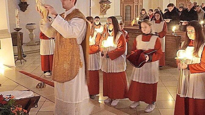 Pfarrer Past&ouml;tter pr&auml;sentierte die kleine Jesusfigur, bevor er sie in die Krippe legte.