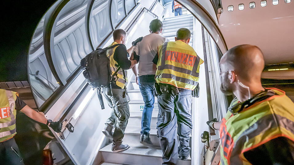 Polizisten begleiten einen Afghanen auf dem Flughafen Leipzig in eine Maschine, die einen Abschiebeflug durchführen soll.
