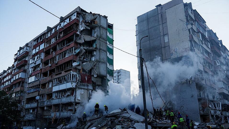 In den Trümmern eines bei einem russischen Angriff teils zerstörten Hauses suchen Helfer nach Verschütteten. In den Trümmern eines bei einem russischen Angriff teils zerstörten Hauses suchen Helfer nach Verschütteten.
