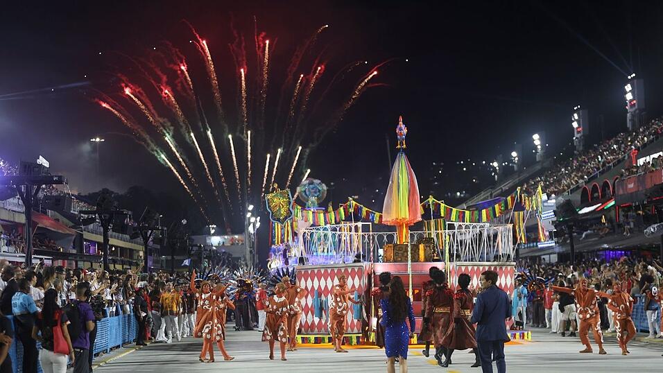 Mehrere Sambaschulen ziehen mit bunten Wagen durch die Stra&szlig;e.