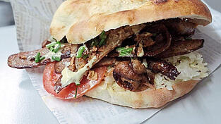 So sieht er aus, der Bratwurstd&ouml;ner: Gef&uuml;llt wird er mit fr&auml;nkischen W&uuml;rstln, d&uuml;nn geschnitten, kross angebraten. Dazu kommen Kraut, Tomaten, R&ouml;stzwiebeln - und ein Klecks So&szlig;e.