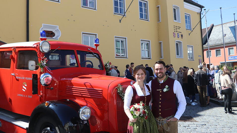 Das Brautpaar mit Gästen vor dem Rathaus.