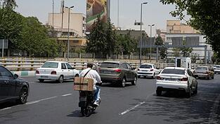 Fahrzeuge fahren in Teheran an einer Plakatwand vorbei, auf der die geballte Faust des verstorbenen iranischen Obersten Führers Ajatollah Ali Chamenei zu sehen ist. (Archivbild) Fahrzeuge fahren in Teheran an einer Plakatwand vorbei, auf der die geballte Faust des verstorbenen iranischen Obersten Führers Ajatollah Ali Chamenei zu sehen ist. (Archivbild)
