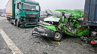 Ein völlig zerstörtes Fahrzeug steht nach einem Unfall auf der Autobahn 93 vor einem Lastwagen. Bei dem Unfall starben mindestens drei Menschen. 