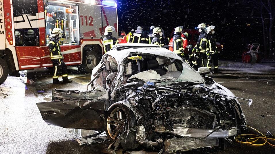 Feuerwehrkräfte stehen an einer Unfallstelle hinter einem Autowrack. Eine Frau starb noch am Unfallort, nachdem ein Autofahrer frontal mit seinem Wagen in ihr Fahrzeug gefahren war. Der Autofahrer wurde später zu einer Gefängnisstrafe von sechs Jahren und drei Monaten verurteilt. Er war mit einem Tempo von etwa 200 Kilometern pro Stunde unterwegs - etwa doppelt so schnell wie erlaubt. Feuerwehrkräfte stehen an einer Unfallstelle hinter einem Autowrack. Eine Frau starb noch am Unfallort, nachdem ein Autofahrer frontal mit seinem Wagen in ihr Fahrzeug gefahren war. Der Autofahrer wurde später zu einer Gefängnisstrafe von sechs Jahren und drei Monaten verurteilt. Er war mit einem Tempo von etwa 200 Kilometern pro Stunde unterwegs - etwa doppelt so schnell wie erlaubt.
