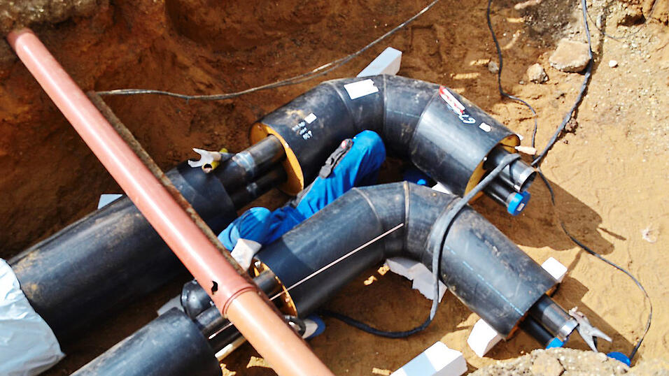 Ein Monteur verschwei&szlig;t die Leitungen.