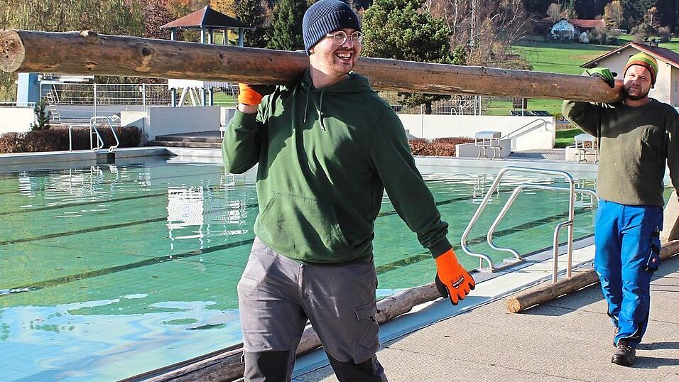 Darius Dahl, Fachangestellter für Bäderbetriebe (vo.), und Michael Kiefl, Elektriker, tragen die Baumstämme zum Becken. Darius Dahl, Fachangestellter für Bäderbetriebe (vo.), und Michael Kiefl, Elektriker, tragen die Baumstämme zum Becken.