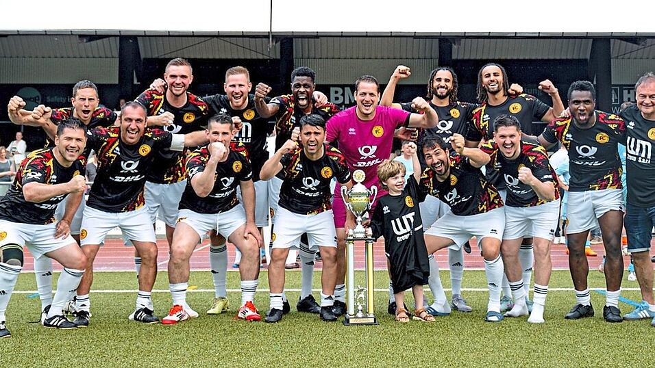 Das Nationalteam der Deutschen Post DHL setzt sich aus Spielern aus ganz Deutschland zusammen, die in h&ouml;herklassigen Amateurligen Fu&szlig;ball spielen. Die Unterst&uuml;tzung besonderer Benefizanl&auml;sse gerade zugunsten von Kindern genie&szlig;t dabei eine hohe Priorit&auml;t. Als Gastspieler und Freund ist gerne auch Mo Idrissou (hinten Mitte) dabei. Gecoacht wird das Team von Detlev Steinebach (rechts).