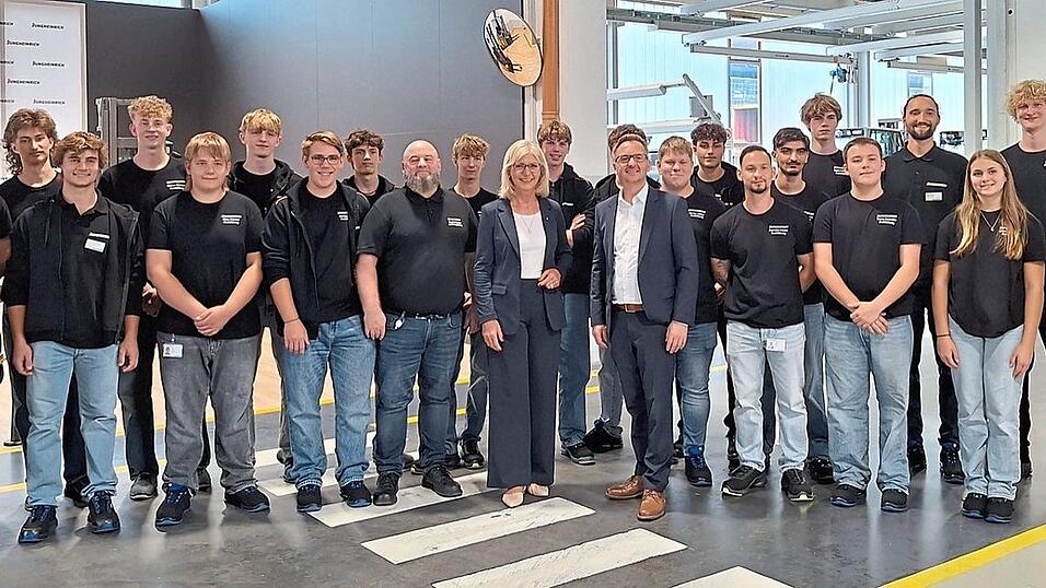 Ministerin Ulrike Scharf (Mitte), Jungheinrich Gesch&auml;ftsleiter Markus Roy (rechts daneben) und Ausbildungsleiter Siegfried Becher (links daneben) mit den neuen Auszubildenden und dualen Studenten.