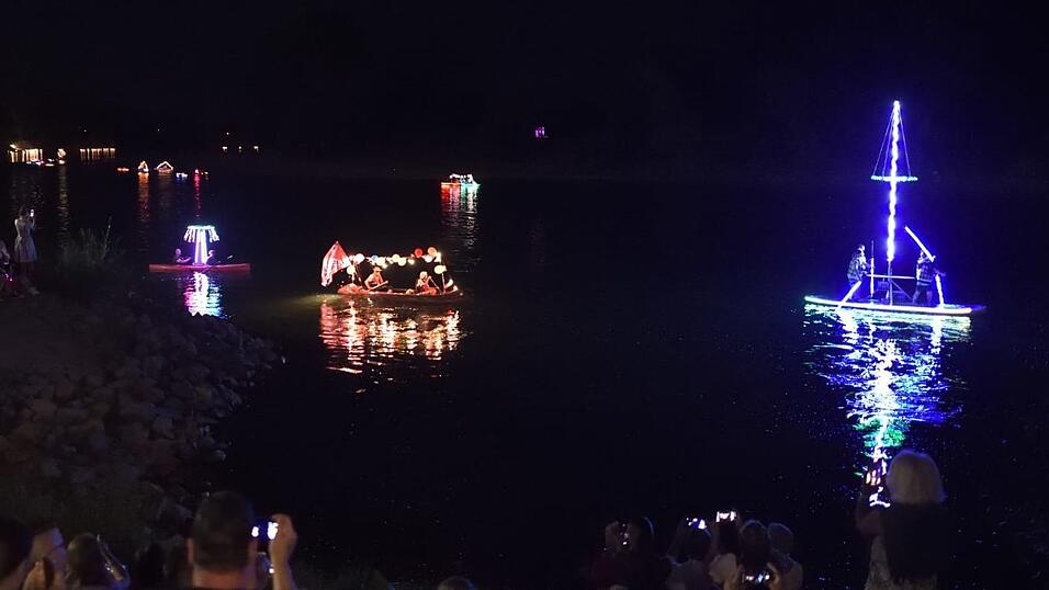 Bunt beleuchtete Boote fahren bei der Lampionfahrt über die Donau.