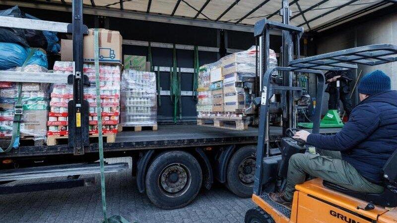 Ein Helfer lädt eine Europalette auf einen Lastwagen. Ein Helfer lädt eine Europalette auf einen Lastwagen.