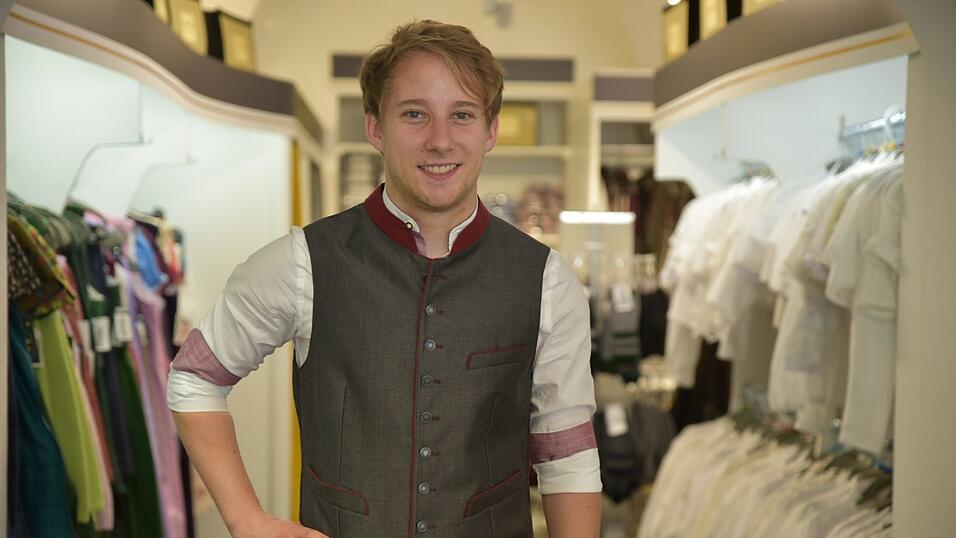 Das weiße Hemd hat rote Details. Dazu passt eine anthrazit-rote Weste. Die bordeauxroten Socken stimmen das Outfit farblich bis ins kleinste Detail ab.