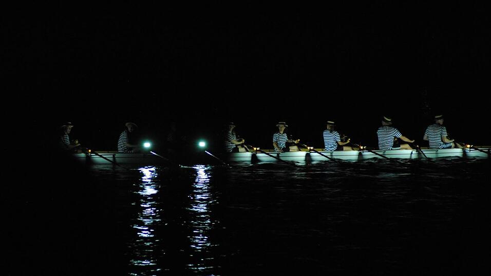 Bunt beleuchtete Boote fahren bei der Lampionfahrt über die Donau.