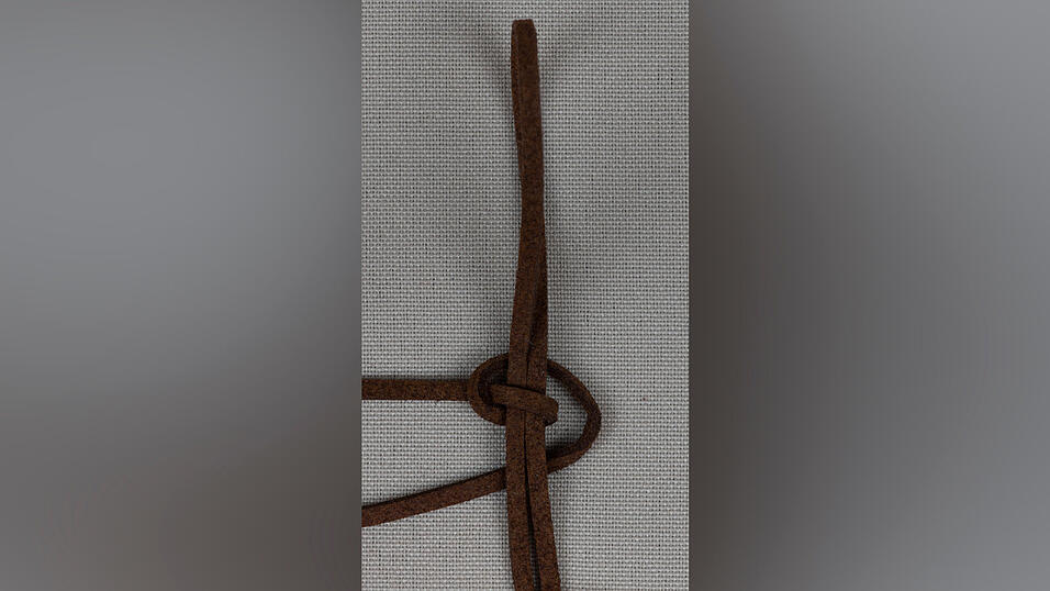 6. Jetzt das Ganze auf der anderen Seite wiederholen. Nimm das rechte Ende und führe es unter dem Ring nach links.