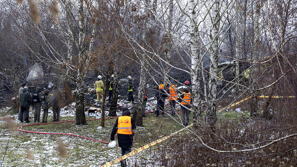 Mitarbeiter des litauischen Katastrophenschutzministeriums arbeiten in der Nähe der Stelle, an der ein DHL-Frachtflugzeug in ein Haus in der Nähe der litauischen Hauptstadt Vilnius, Litauen, gestürzt ist. Mitarbeiter des litauischen Katastrophenschutzministeriums arbeiten in der Nähe der Stelle, an der ein DHL-Frachtflugzeug in ein Haus in der Nähe der litauischen Hauptstadt Vilnius, Litauen, gestürzt ist.