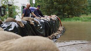 Feuerwehrleute am Montagvormittag in Matting. Dort sind Sandsackw&auml;lle an der Donau aufgebaut.