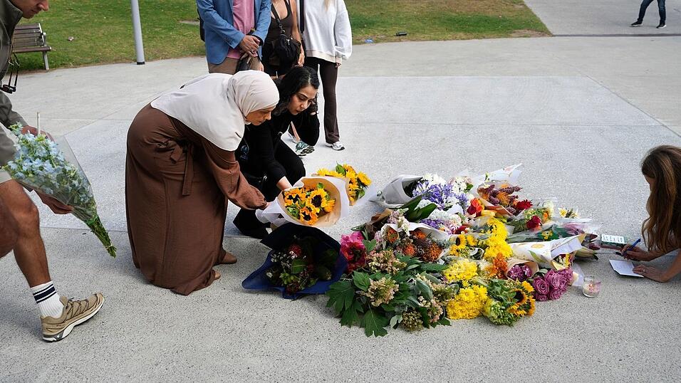 Zahlreiche Menschen legen am Tatort Blumen nieder. Zahlreiche Menschen legen am Tatort Blumen nieder.
