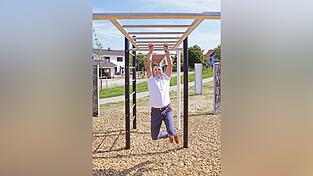 Ein Bürgermeister lässt sich hängen. Oder: Ein Bürgermeister hangelt sich durch. Die Wortspiele drängen sich förmlich auf. Zu sehen ist Josef Schütz beim Erproben eines Fitnessgeräts auf dem Spielplatz am Grünanger.